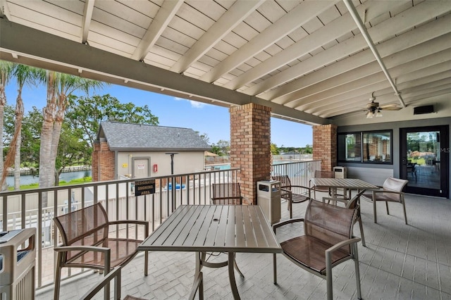 view of patio / terrace with a water view, outdoor dining space, and ceiling fan