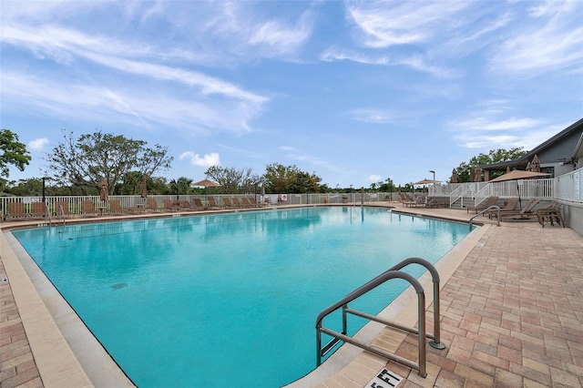 community pool featuring fence and a patio
