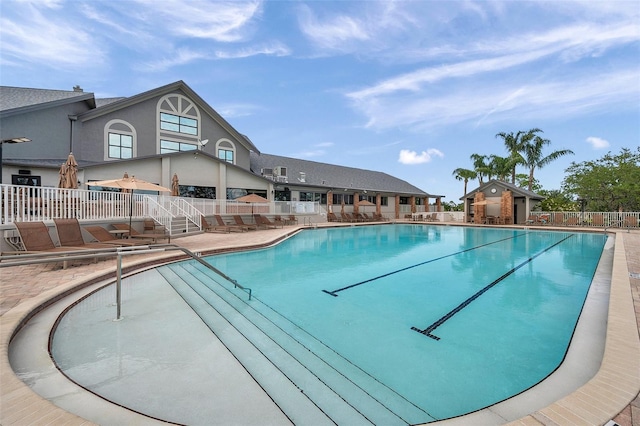 community pool featuring fence and a patio area