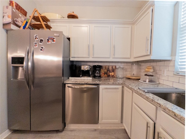 12408 Country White Cir, Tampa, FL 33635 - kitchen featuring appliances with stainless steel finishes, white cabinetry, decorative backsplash, and light stone counters
