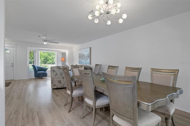dining space with wood finished floors, a chandelier, baseboards, and ceiling fan