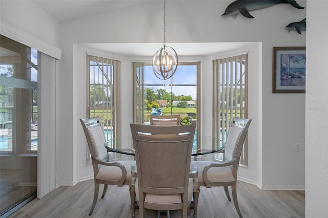dining space featuring wood finished floors, a chandelier, and baseboards