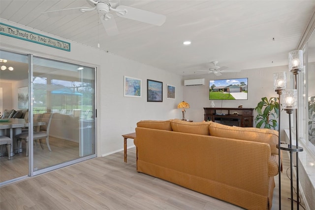 living room featuring ceiling fan, a wall mounted AC, light wood-style floors, baseboards, and recessed lighting