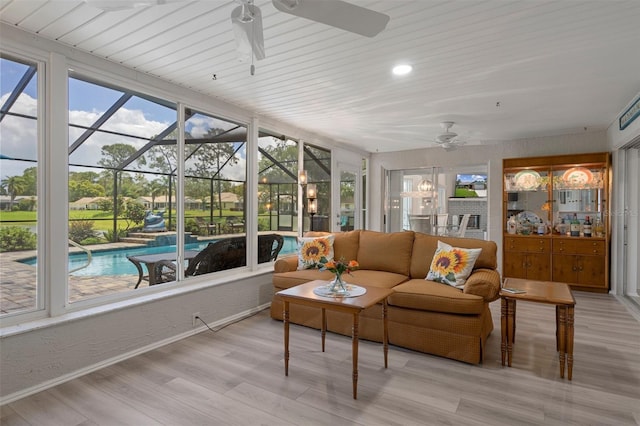 sunroom with ceiling fan and an outdoor living space