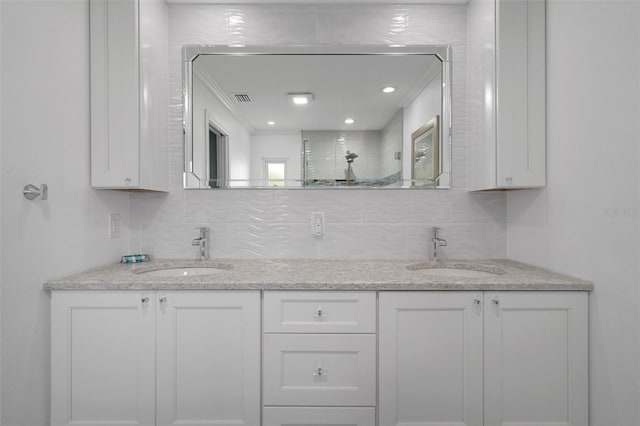 bathroom with backsplash, a walk in shower, double vanity, and ornamental molding