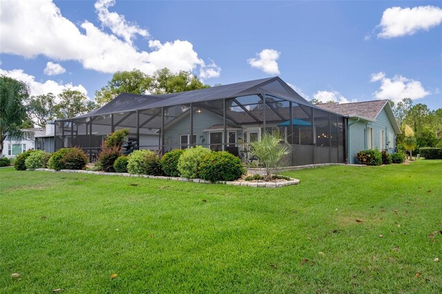 rear view of property with a lawn and a lanai