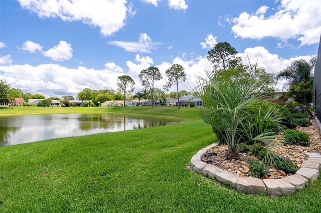 view of grassy yard featuring a water view and a residential view