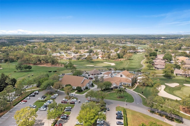 aerial view of property and surrounding area featuring a local golf course and nearby suburban area