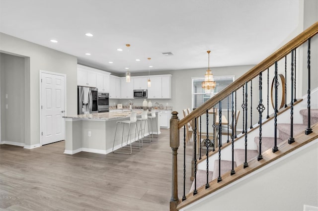12854 Rangeland Blvd, Odessa, FL 33556 - kitchen with appliances with stainless steel finishes, light wood finished floors, baseboards, white cabinets, and recessed lighting