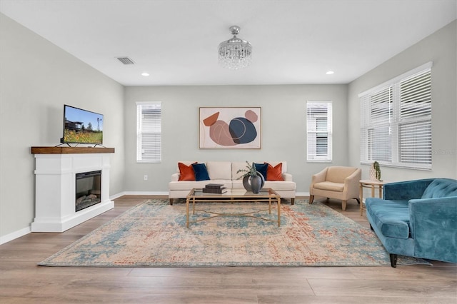 12854 Rangeland Blvd, Odessa, FL 33556 - living area featuring wood finished floors, baseboards, recessed lighting, and a glass covered fireplace