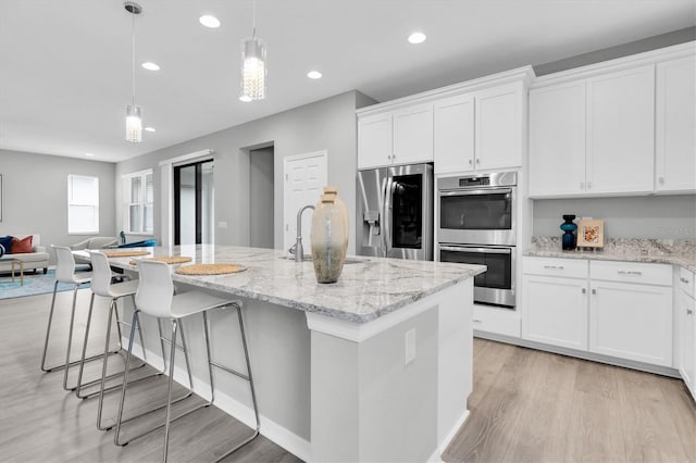 12854 Rangeland Blvd, Odessa, FL 33556 - kitchen featuring appliances with stainless steel finishes, a sink, light wood finished floors, recessed lighting, and white cabinets