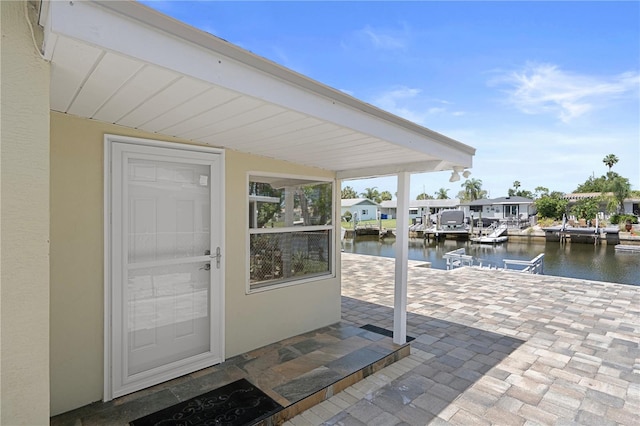 5045 Pelican Dr, New Port Richey, FL 34652 - property entrance with a water view, stucco siding, and a patio