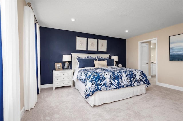 carpeted bedroom featuring baseboards, ensuite bath, and recessed lighting