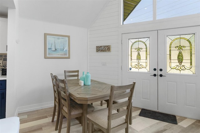 7422 New York Ave, Hudson, FL 34667 - dining space featuring lofted ceiling, light wood-type flooring, french doors, and baseboards