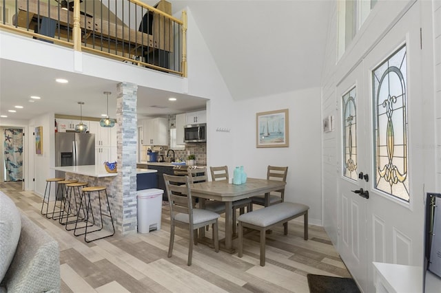 7422 New York Ave, Hudson, FL 34667 - dining space featuring a high ceiling, light wood-style flooring, baseboards, decorative columns, and recessed lighting