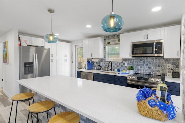 7422 New York Ave, Hudson, FL 34667 - kitchen with appliances with stainless steel finishes, a sink, a breakfast bar area, light countertops, and pendant lighting
