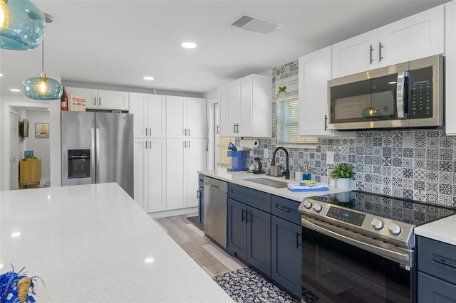 7422 New York Ave, Hudson, FL 34667 - kitchen with stainless steel appliances, a sink, white cabinetry, decorative backsplash, and recessed lighting