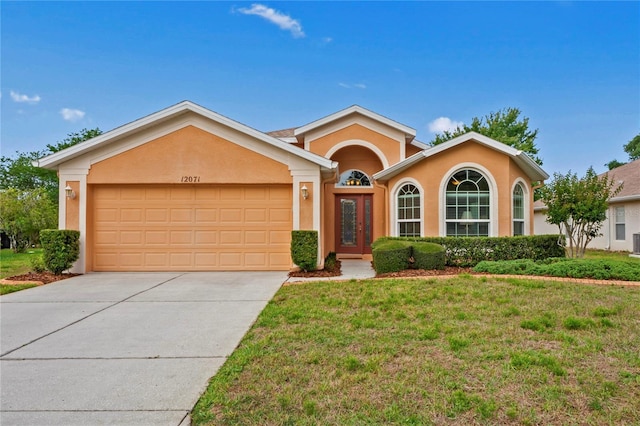 12071 Wexford Blvd, Spring Hill, FL 34609 - ranch-style house with stucco siding, an attached garage, driveway, and a front lawn