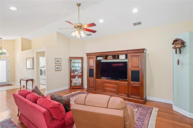 12071 Wexford Blvd, Spring Hill, FL 34609 - living room with light wood-type flooring, lofted ceiling, a ceiling fan, baseboards, and washer / clothes dryer