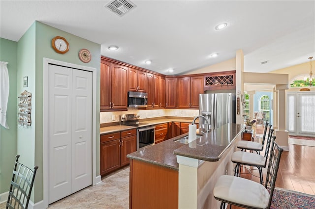 12071 Wexford Blvd, Spring Hill, FL 34609 - kitchen with a sink, appliances with stainless steel finishes, a kitchen breakfast bar, dark stone counters, and vaulted ceiling