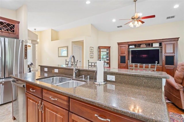 12071 Wexford Blvd, Spring Hill, FL 34609 - kitchen featuring a sink, appliances with stainless steel finishes, open floor plan, ceiling fan, and dark stone counters