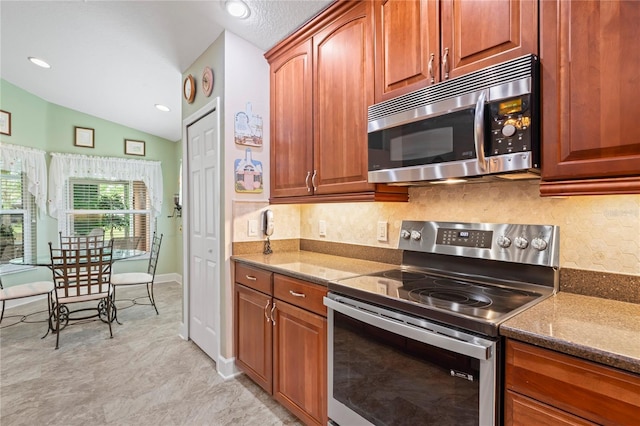 12071 Wexford Blvd, Spring Hill, FL 34609 - kitchen with stainless steel appliances, vaulted ceiling, tasteful backsplash, dark stone countertops, and baseboards