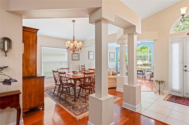 12071 Wexford Blvd, Spring Hill, FL 34609 - dining space with light wood finished floors, a chandelier, vaulted ceiling, and baseboards