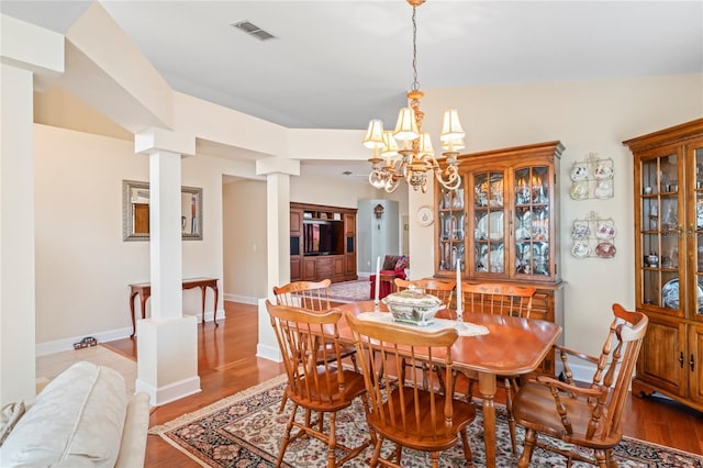 12071 Wexford Blvd, Spring Hill, FL 34609 - dining area featuring decorative columns, wood finished floors, a chandelier, and baseboards