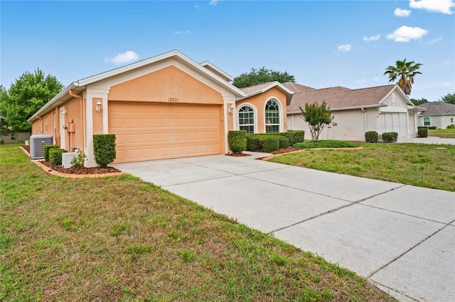 12071 Wexford Blvd, Spring Hill, FL 34609 - ranch-style home featuring central AC unit, an attached garage, concrete driveway, a front lawn, and stucco siding