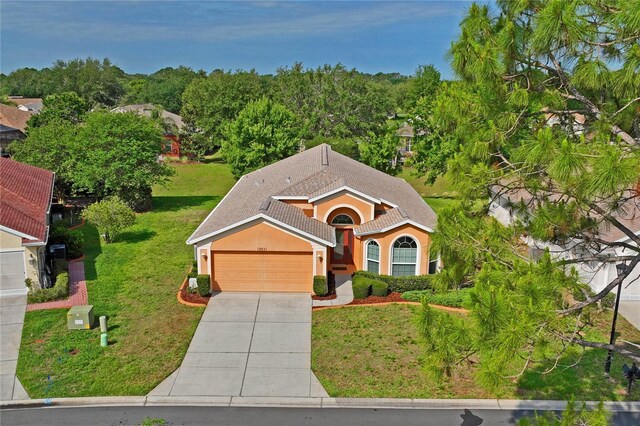 12071 Wexford Blvd, Spring Hill, FL 34609 - view of front facade with an attached garage, driveway, a front yard, and stucco siding