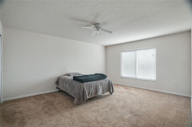 bedroom featuring carpet flooring, a textured ceiling, baseboards, and a ceiling fan