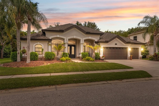15413 Azra Dr, Odessa, FL 33556 - mediterranean / spanish home with concrete driveway, a garage, stucco siding, a front yard, and french doors