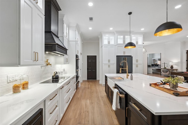 15413 Azra Dr, Odessa, FL 33556 - kitchen featuring custom range hood, black appliances, a sink, a spacious island, and white cabinetry