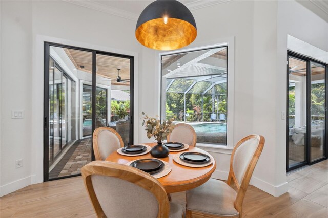 15413 Azra Dr, Odessa, FL 33556 - dining area featuring a sunroom, ornamental molding, baseboards, ceiling fan, and light wood-style flooring