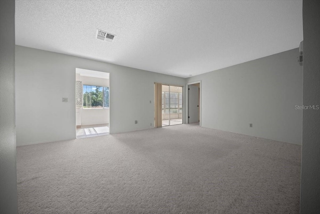 carpeted empty room featuring a textured ceiling