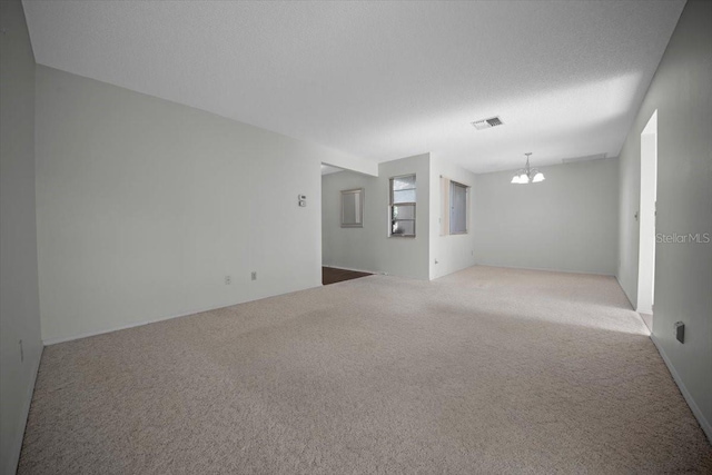 unfurnished room with a chandelier and carpet