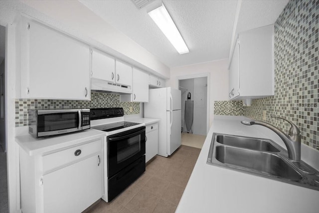kitchen with electric range, under cabinet range hood, stainless steel microwave, a sink, and freestanding refrigerator