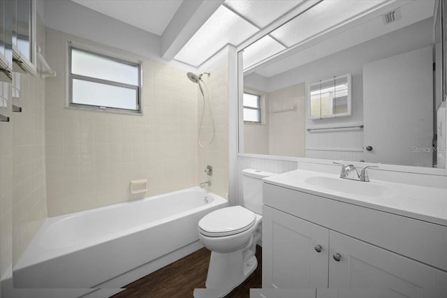bathroom featuring toilet, shower / tub combination, vanity, wood finished floors, and plenty of natural light