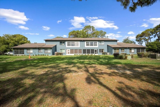 back of property featuring stucco siding and a lawn