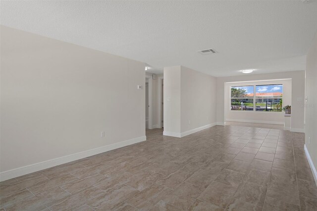4937 Dory Dr, New Port Richey, FL 34652 - empty room with a textured ceiling and baseboards