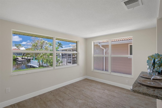 4937 Dory Dr, New Port Richey, FL 34652 - spare room featuring a textured ceiling, healthy amount of natural light, and baseboards