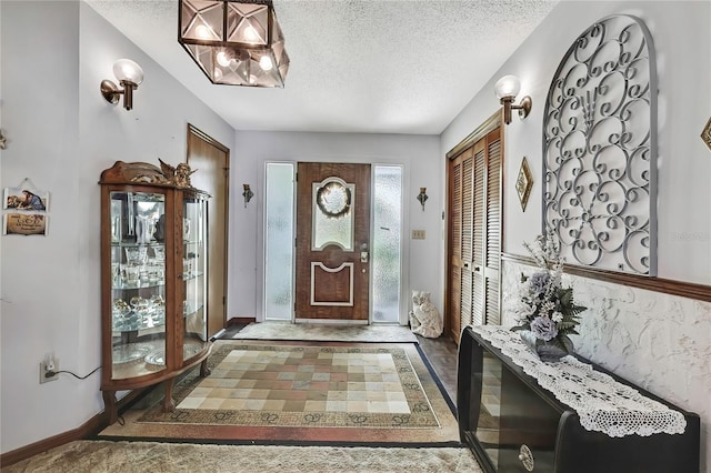 entrance foyer with a textured ceiling and baseboards