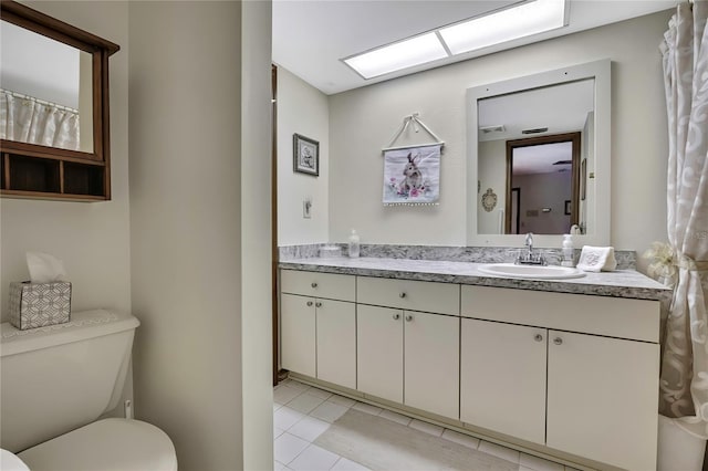 bathroom featuring toilet, vanity, and tile patterned flooring