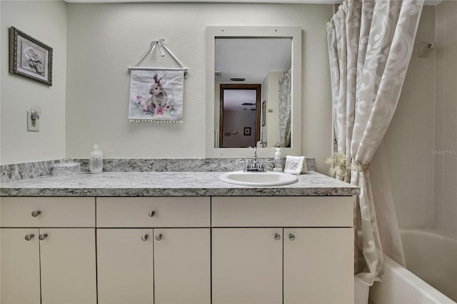 bathroom featuring vanity and shower / bathtub combination with curtain