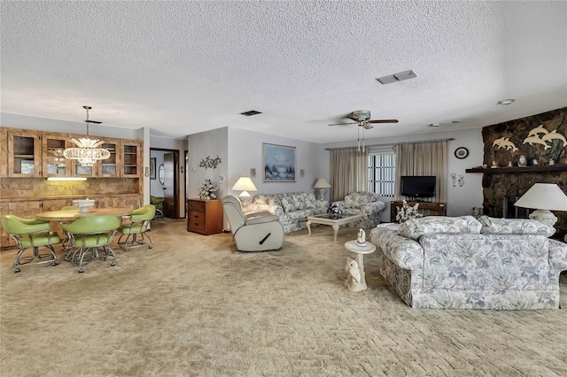 carpeted living area with a chandelier, a textured ceiling, and ceiling fan