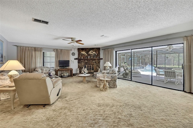 carpeted living room with a textured ceiling and a ceiling fan