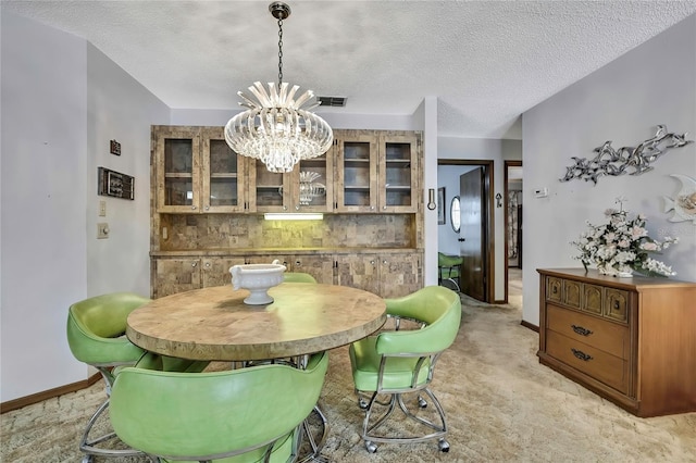 dining room with a chandelier, baseboards, and a textured ceiling