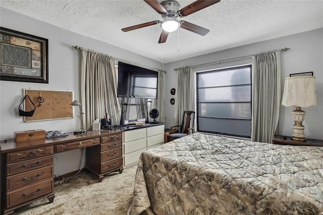 bedroom featuring a textured ceiling, an office area, light colored carpet, and a ceiling fan