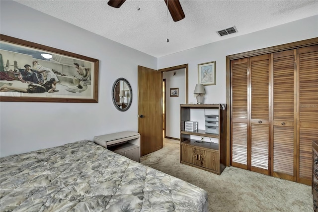 carpeted bedroom featuring a closet, ceiling fan, and a textured ceiling