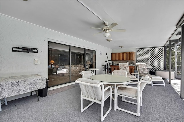 view of patio featuring a ceiling fan, outdoor dining area, and an outdoor kitchen